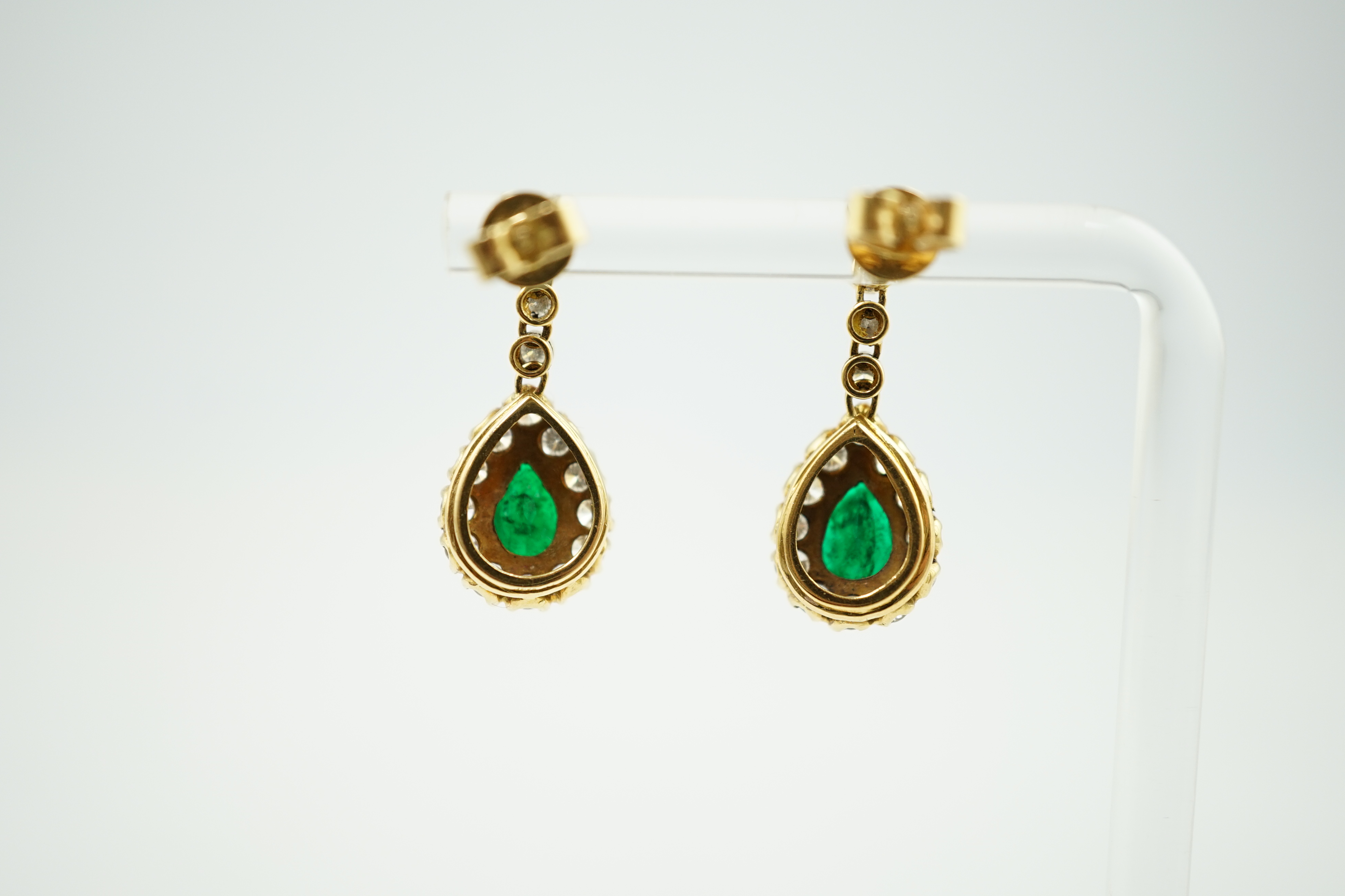 A modern pair of 18ct gold, emerald and diamond cluster set pear shaped drop earrings